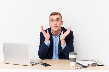 Young business man with a laptop surprised and shocked.