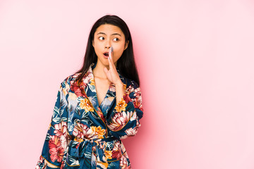 Young chinese woman wearing a asiatic pijama isolated pointing temple with finger, thinking, focused on a task.