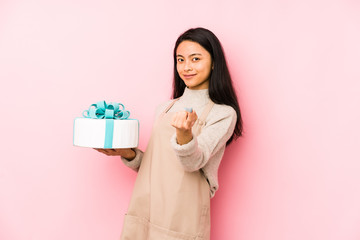 Young chinese woman holding a cake isolated having an idea, inspiration concept.