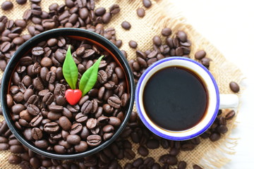 Coffee beans decorated with red heart and green leaves