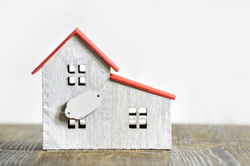 Model of a wooden house with a sign. Home sale purchase concept
