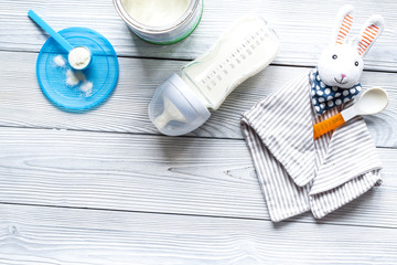 preparation of mixture baby feeding on wooden background top view