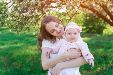 Young beautiful woman holds on hands of the little daughter. Parenthood motherhood concept