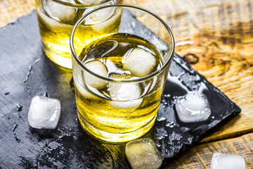 glass of whiskey on wooden background