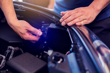 The hand of a mechanic is checking the connectors of car engine. Checking the engine by yourself. Car quality inspection in the automobile industry. Quality Control Concept. (QC)