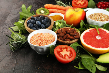 Healthy food clean eating selection: fish, fruit, vegetable, cereal, leaf vegetable on rustic background