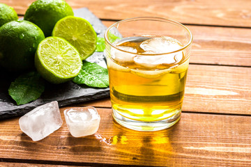 glass of whiskey on wooden background