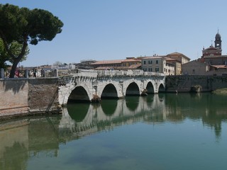 Fototapeta na wymiar Rimini – Bridge of Tiberius crossing the Marecchia river built of white Istrian stone and characterized by five semicircular arches