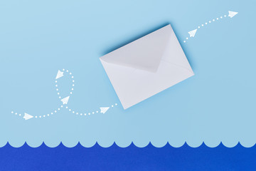 White envelope flying above paper sea with indicated direction by white points and arrows depicted with drawn airplanes. Mail concept