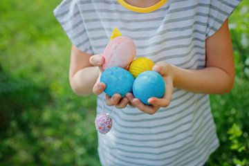 Fototapeta na wymiar hands of child holding colorful eggs on Easter Day. easter, holiday and child concept