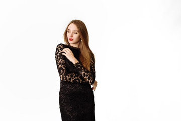 Sexy beautiful pensive girl in a black lace dress in the studio. Beautiful lady isolated on a white background