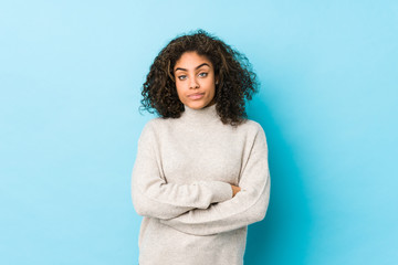 Young african american curly hair woman unhappy looking in camera with sarcastic expression.