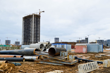 Large black plastic and concrete stone cement sewer plumbing pipes for the construction of water pipes or sewers at a construction site during the repair