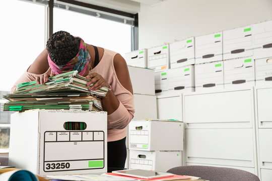 A woman laying her head down on top of a stack of files, Jacksonville, Florida, USA