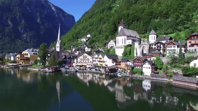 Beautiful 4k aerial drone panorama flight over small house Austria village in wild nature forest mountain lake landscape
