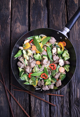 Chinese cuisine.  chinese beef in spicy sauce with rice and  vegetables.  Colorful stir fry in a wok.