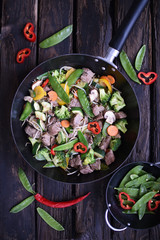 Chinese cuisine.  chinese beef in spicy sauce with rice and  vegetables.  Colorful stir fry in a wok.