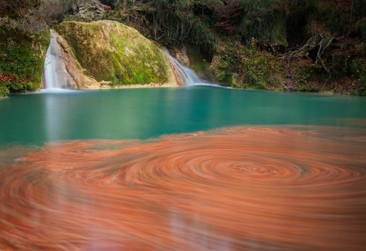 Swirl of autumn leaves in Urederr river, Urbassa-Andia Natural Park, Navarre, Spain