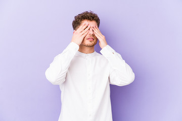 Young blond curly hair caucasian man isolated afraid covering eyes with hands.