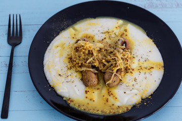 vegan version of bangers and mash potato with veggie sausages topped with sauerkraut