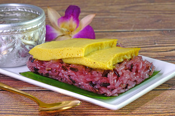 Traditional Thai dessert : Sweet Purple Sticky rice with Thai egg custard. Selective focus.