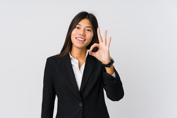 Young asian business woman cheerful and confident showing ok gesture.