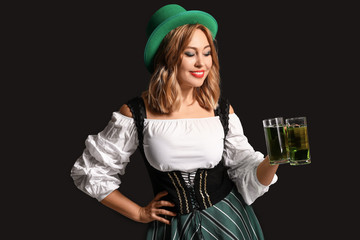 Beautiful young woman with beer on dark background. St. Patrick's Day celebration