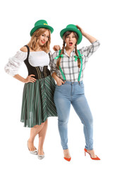 Funny young women on white background. St. Patrick's Day celebration