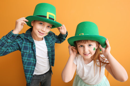 Funny little children on color background. St. Patrick's Day celebration