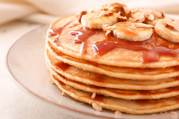 Plate with stack of tasty pancakes on table, closeup