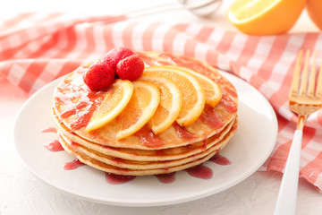 Plate with stack of tasty pancakes on table