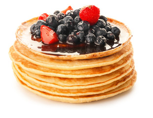 Stack of tasty pancakes with berries on white background