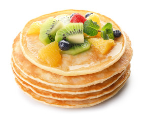 Stack of tasty pancakes with fruits on white background