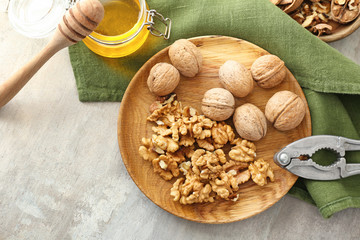 Composition with tasty walnuts and honey on table