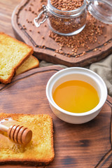 Sweet honey and toasted bread on table