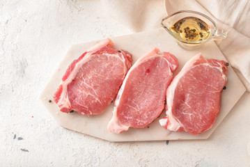 Raw pork meat with oil on table