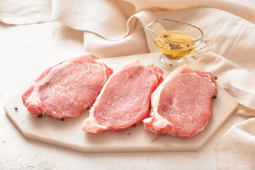 Raw pork meat with oil on table