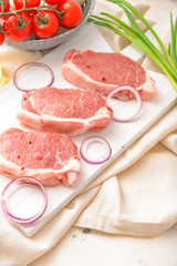 Raw pork meat with onion on table