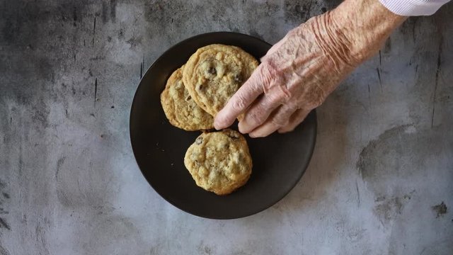 Taking Chocolate Chip Cookies from a Plate