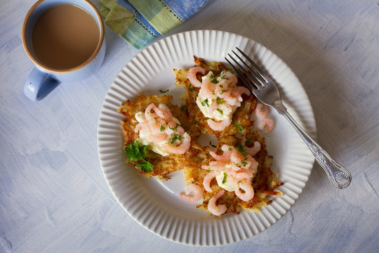 Potato cakes with topping: cream cheese and shrimps on white plate. Vegetable fritters, pancakes. Overhead horizontal image