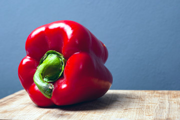 sweet red big paprika pepper on a gray background with copy space close-up