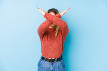 young caucasian woman posing isolated keeping two arms crossed, denial concept.