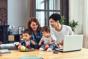 Happy international family concept. Dad, mom, son and little daughter posing for a camera at home, are engaged in home parenting. Home holidays, parenting, concept children and parents.