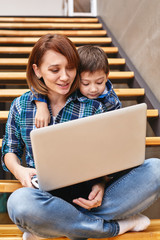 Mom and son are doing homework on the computer. Concept mom and children, modern technology and the Internet.