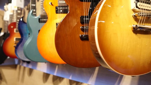 Guitar Player with leather jacket selection of guitars in shop in sunset boulevard los angeles hanging electrics branded