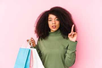 Young afro woman shopping isolated Young afro woman buying isolaYoung afro woman holding a roses isolated having some great idea, concept of creativity.< mixto >