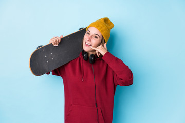 young skater caucasian woman isolated showing a mobile phone call gesture with fingers. © Asier