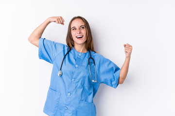 Young nurse woman isolated raising fist after a victory, winner concept.