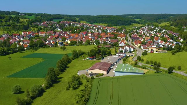 Aerial of Ostelsheim, Germany.  Camera zooms in and rotates right, tilting down as it passes over the town.