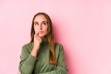 Young caucasian woman posing isolated  looking sideways with doubtful and skeptical expression.